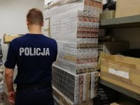 policjant umundurowany obok paczki papierosów bez polskich znaków akcyzy