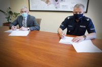 Komendanta Powiatowy Policji w Kutnie i Prezydent Miasta Kutna siedzą za stołem podpisują porozumienie