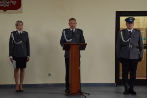 Komendant Powiatowy Policji w Kutnie przemawia przy mównicy po prawej stronie stoi mistrz ceremonii, po lewej lektor