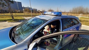 policjantka siedzi w radiowozie z dzieckiem na kolanach
