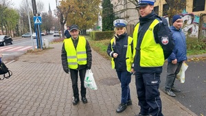 Policjanci rozdają kamizelki odblaskowe osobom pieszym w Kutnie.