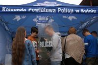 namiot niebieski z napisem Komenda Powiatowa Policji w Kutnie, osoby zainteresowane oglądają sprzęt policyjny