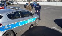 Radiowóz oznakowany , przed nimi stoi umundurowany policjant oraz żołnierz z WOT