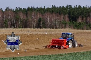 ciągnik na polu,  w rogu policyjna odznaka