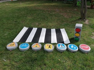 rekwizyty: gumowe przejście dla pieszych, znaki drogowe lezą na trawie