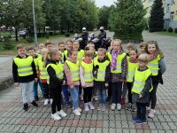 klasa w kamizelkach odblaskowych śpiewa piosenkę , dzieci trzymają mikrofony, w tle motocykle policyjne