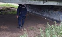 Policjant wchodzi pod most, kontroluje czy nie przebywają tam bezdomni