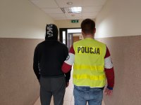 policjant prowadzi zatrzymanego mężczyzne