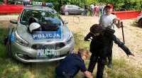 radiowóz policyjny w lesie, dziewczynka przymierza strój policjanta