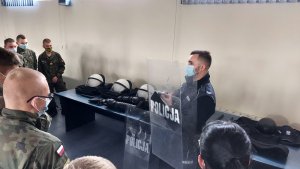 sala odpraw w KPP Kutno, policjant pokazuje sprzęt uczniom szkoły mundurowej