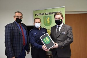 pokój w starostwie po lewej stronie członek zarządu w środku komendant komisariatu policji po prawej stronie starosta , komendant i starosta razem trzymają alkomat