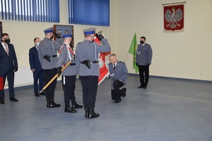 sala odpraw poczet sztandarowy stoi na środku sali, sztandarowy wyrzucił sztandar komendant klęka całuje sztandar