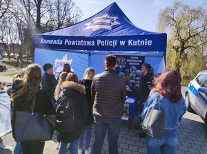 namiot niebieski Komenda Powiatowa Policji w Kutnie przed namiotem stoją ludzie obok zaparkowany radiowóz policyjny