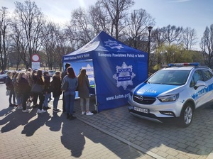 namiot niebieski Komenda Powiatowa Policji w Kutnie przed namiotem stoją ludzie obok zaparkowany radiowóz policyjny