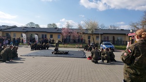 parking na środku mata , uczniowie szykują sie do pokazu, z tyłu widownia