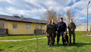 policjant z psem służbowym obok uczniowie ze szkoły mundurowej