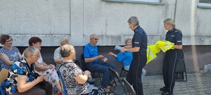 policjantki rozdają kamizelki odblaskowe i ulotki