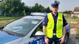 policjant stoi przy radiowozie