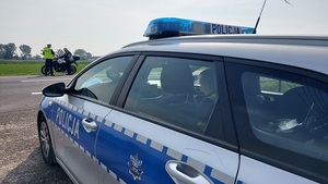 radiowóz w tle policjant rozmawia z motocyklistą