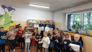 klasa, zdjęcie grupowe, policjantki trzymają w ręku rysunki namalowane przez dzieci