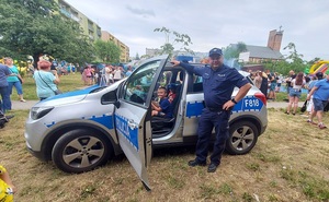 policjant pokazuje dzieciom radiowóz.