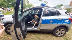 policjant pokazuje dzieciom radiowóz.