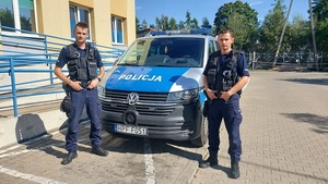 policjanci stojący przy radiowozie przed Komendą Powiatową Policji.