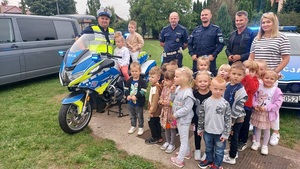 policjanci wraz z przedszkolakami obok motocykla policyjnego.