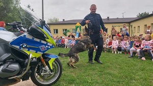 policjanci z pieskiem służbowym i dziećmi z przedszkola.