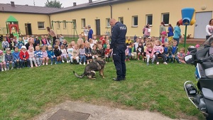 policjanci z pieskiem służbowym i dziećmi z przedszkola.