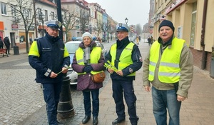 policjanci rozdają elementy odblaskowe pieszym.