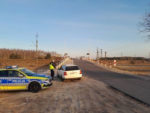 Przejazd kolejowy kontrola pojazdu przez policjanta ruchu drogowego.