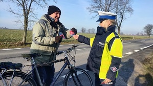 Policjantka wręcza serduszko kierowcy.