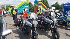 dzieci siedzące na motocyklach policyjnych.