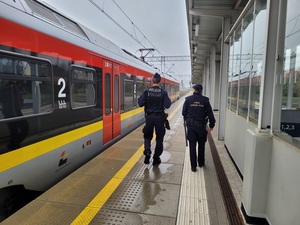 policjant i funkcjonariusz Straży Ochrony Kolei wspólnie patrolują rejon dworca.