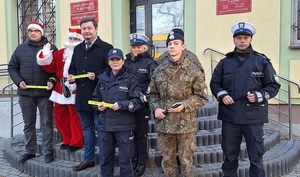 Policjanci wraz z władzami starostwa powiatowego, uczniami Liceum Mundurowego oraz Mikołajem stoją przed budynkiem urzędu.