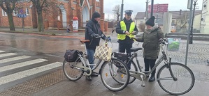 Policjant przekazuje odblaski mieszkańcom.