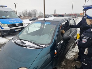 policjanci podczas kontroli pojazdu rozdają zawieszki w kształcie serduszek.