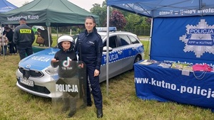 policjantka podczas prezentacji sprzętu taktycznego policyjnego z dzieckiem.