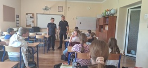 dzielnicowy i policjantka na spotkaniu z uczniami w szkole.