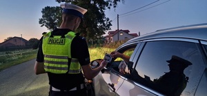 policjant daje kierującemu ulotkę &quot;mistrzu zwolnij&quot;.