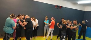 policjanci podczas zajęć na macie z kobietami.