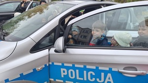 dzieci siedzące w radiowozie policyjnym.
