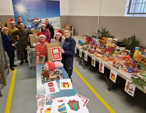 policjantka wraz z funkcjonariuszami i pracownikami Trzeciej Regionalnej Bazy Logistycznej podczas pakowania prezentów dla rodziny.