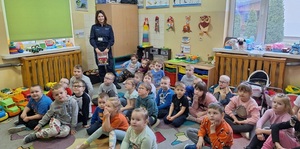 policjantka z dziećmi z przedszkola podczas prelekcji.