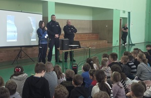 policjantka z dzielnicowymi podczas spotkania z dziećmi w szkole.