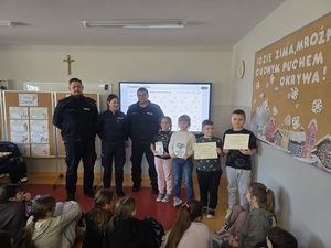 policjantka z dzielnicowymi podczas spotkania z dziećmi w szkole.