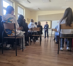policjantka podczas spotkania z młodzieżą w szkole.