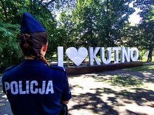 policjantka stojąca tyłem a w tle napis Kutno.