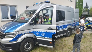 policjant z dziećmi przy radiowozie.
